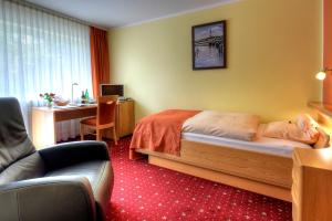 ein Hotelzimmer mit einem Bett und einem Schreibtisch in der Unterkunft Hotel Katharina Garni in Tübingen