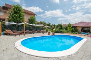 a swimming pool in a yard with chairs and a house at Villa Rubčić Rooms in Rakovica