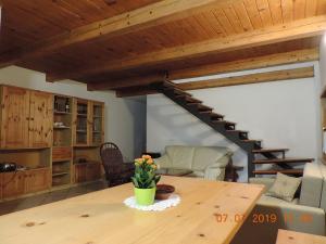 een woonkamer met een houten tafel en een trap bij Guest House Nanos in Vipava