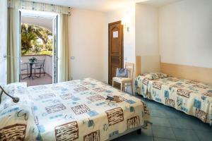 a hotel room with two beds and a balcony at Hotel Terme Royal Palm in Ischia