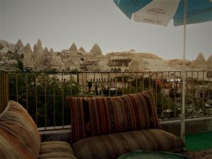 a couch on a balcony with a view of a city at Homestay Cave Hostel in Goreme