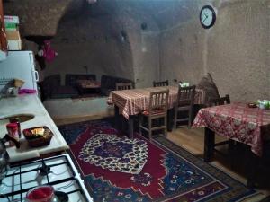 a kitchen with a table and chairs and a room with a couch at Homestay Cave Hostel in Göreme