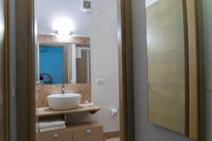 un bagno con lavandino e specchio di Il Borgo Del Principino a Favignana Altre 37 foto