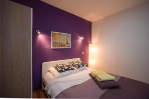 Un dormitorio con una pared púrpura y una cama en Villa Rubčić en Rakovica