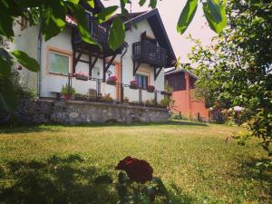 a house with balconies and a yard with grass at Konak Pahulja TARA in Bajina Bašta