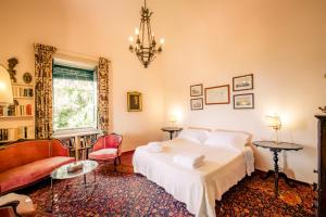 ein Schlafzimmer mit einem Bett, einem Stuhl und einem Kronleuchter in der Unterkunft Villa Gemmellaro in Taormina