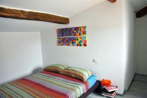 un letto in una stanza con un dipinto sul muro di Piazza Arnolfo 1932 a Colle Val D'Elsa