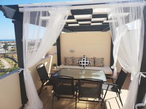 un balcone con tavolo, sedie e divano di Atico con piscina privada a Vera