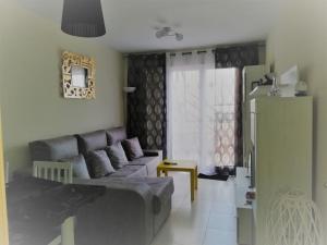 un soggiorno con un divano e una finestra di Atico con piscina privada a Vera