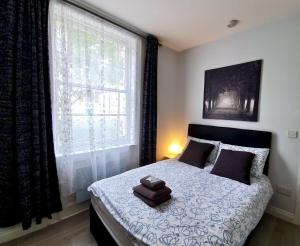 um quarto com uma cama com duas toalhas em Victoria Lodgings London em Londres