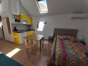 Un dormitorio con una cama y una mesa y una cocina. en Tipico Romântico II, en Setúbal