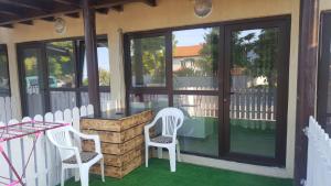 a patio with two white chairs and a table at Luxuries Beta in Saturn