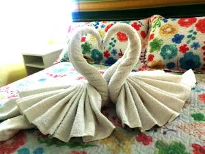 two swans wrapped in towels sitting on a bed at Apartamento Pepe in Playa del Ingles