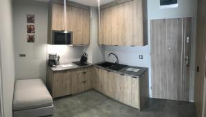 kuchnia z drewnianymi szafkami i zlewem w obiekcie Apartament Silver Klifowa w Rewalu