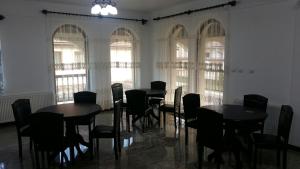 a dining room with tables and chairs and windows at Agropensiunea Izana in Drăguţeşti +29 photos