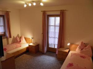 une chambre avec deux lits et une fenêtre dans l'établissement Flatscherhof, à San Lorenzo di Sebato