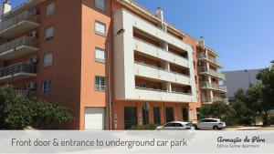 un edificio alto con macchine parcheggiate di fronte di Edificio Solmar Apartment ad Armação de Pêra