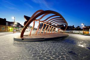 a sculpture on a sidewalk in a city at night at Vitamine Zee in Petten