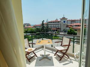 a patio with a table and chairs on a balcony at Milennia Family Hotel in Sunny Beach