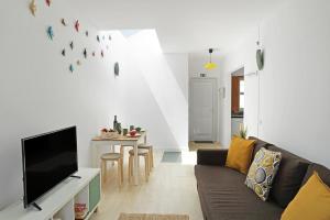 uma sala de estar com um sofá e uma televisão em Mood Lodging - Caldas & Ocean em Óbidos
