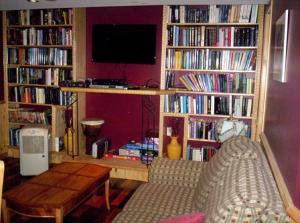 a living room with several book shelves filled with books at Gîte Au p'tit bonheur B&B in Coaticook
