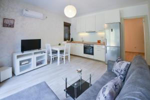a living room with a couch and a kitchen at Brand New Apartments - free parking in Sveti Stefan