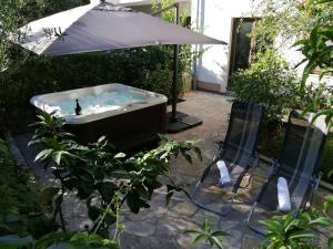 烏格連島的住宿－Apartments Mrva，热水浴池配有遮阳伞和2把椅子