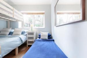 1 dormitorio con 2 literas y espejo en 3 Bedroom Garden Flat - Central Location, en Londres