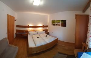 a bedroom with a large bed with white sheets at Ferienwohnung Christina Gundolf in Wenns