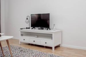 a white entertainment center with a flat screen tv on it at City Break Apartment in Visoko