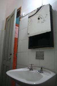 y baño con lavabo blanco y espejo. en Andamundos Hostel en Mina Clavero