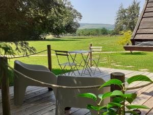 a patio with a table and chairs and a field at Cabane Aligoté in Saint-Albain