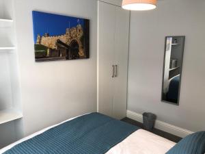 a bedroom with a bed and a picture on the wall at Archie's Cottage in Lincoln