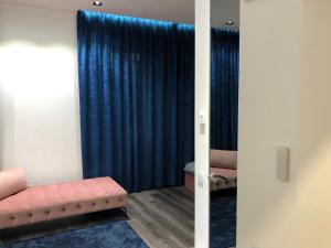 Habitación con sofá y cortina azul en Modern and Luxury Apartment in the Center of Kaunas, en Kaunas