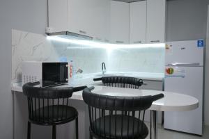 a kitchen with a counter with chairs and a microwave at ASIA Hotel in Almaty