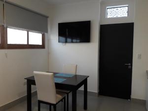 uma sala de jantar com uma mesa e uma porta preta em Apart Camilo em Mendoza