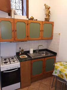 a kitchen with a sink and a stove at BILOCALE VERDI A C/MARE GOLFO in Castellammare del Golfo