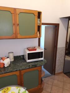 a kitchen with a microwave on a counter next to a door at BILOCALE VERDI A C/MARE GOLFO in Castellammare del Golfo