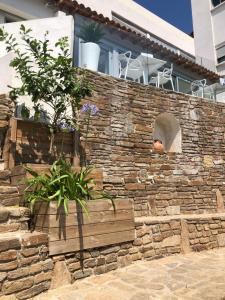 a stone wall with a planter in front of a house at Hotel La Voile in Bormes-les-Mimosas