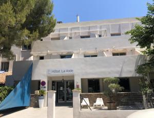 a building with a sign for the hotel la wolfle at Hotel La Voile in Bormes-les-Mimosas