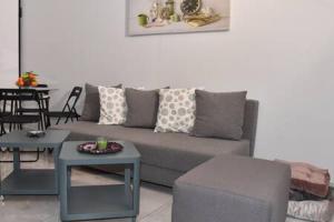 un soggiorno con divano grigio e tavolo di Cozy, newly renovated apt near the City Center ad Atene