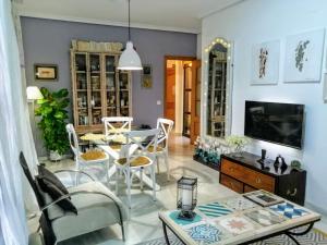 uma sala de estar com uma mesa e cadeiras e uma televisão em Ziza em Córdoba