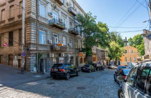 eine Straße mit Autos, die an der Seite eines Gebäudes geparkt sind in der Unterkunft Irina's cozy apartment #21 in Tbilisi City
