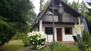 uma casa branca com um telhado preto e branco em Dom nad jeziorem em Gostynin