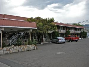 un estacionamiento frente a un edificio con un camión rojo en Royal Motor Inn, en La Grande