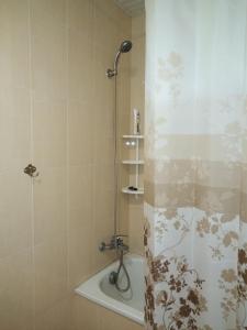 a shower with a shower curtain in a bathroom at REST Guest House in Yerevan