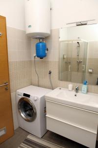een badkamer met een wasmachine en een wastafel bij Trendy Apartment Izola JS in Izola