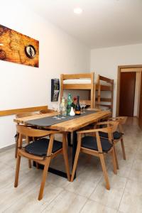 een eetkamer met een houten tafel en stoelen bij Trendy Apartment Izola JS in Izola