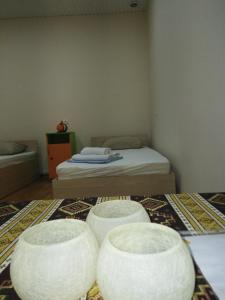a small room with a bed and three white stools at REST Guest House in Yerevan