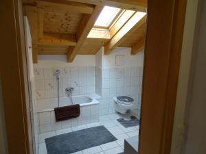 a bathroom with a tub and a toilet and a window at Ferienwohnung Frieda in Inzell